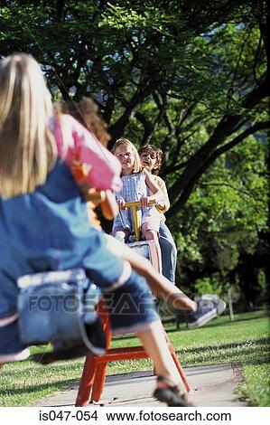 Kids on a see-saw View Large Photo Image Picture - Kids on a see-saw. Fotosearch