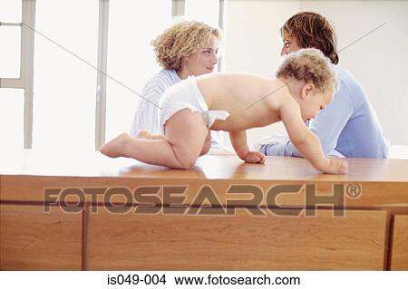 Picture - Baby crawling with parents. Fotosearch