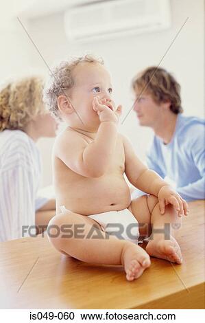 Baby with parents in the background View Large Photo Image Stock Image - Baby with parents in the background. Fotosearch