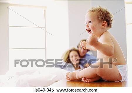 Baby with parents in the background View Large Photo Image Stock Photography - Baby with parents in the background. Fotosearch