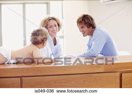 Proud parents looking at baby View Large Photo Image Stock Photograph - Proud parents looking at baby. Fotosearch