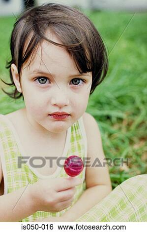 Little girl with a lollipop View Large Photo Image Stock Photograph - Little girl with a lollipop. Fotosearch