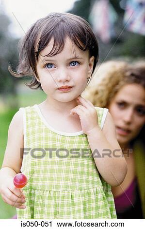 Stock Image - Little girl with mother in the background. Fotosearch