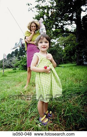 Little girl with mother in the background View Large Photo Image Stock Photo - Little girl with mother in the background. Fotosearch