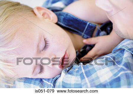 Stock Photo - Baby sleeping in dad's arms. Fotosearch
