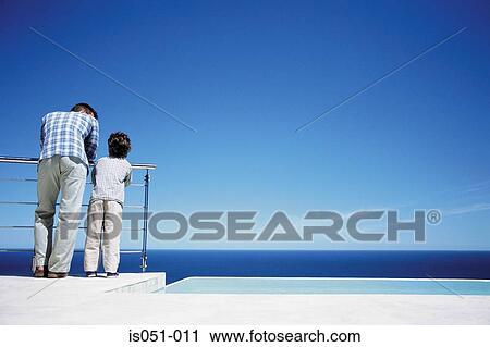 Father and son enjoying a view of the sea View Large Photo Image Stock Image - Father and son enjoying a view of the sea. Fotosearch