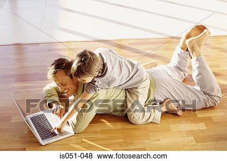 Father and son playing with a laptop View Large Photo Image Stock Photo - Father and son playing with a laptop. Fotosearch