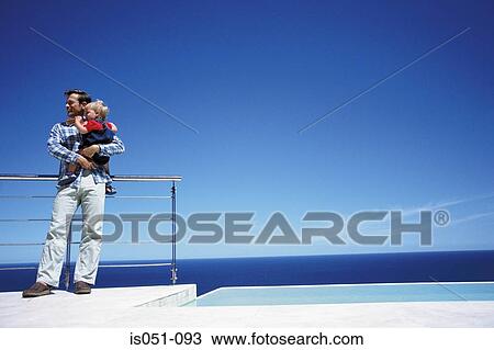 Father holding toddler while enjoying a view of the sea View Large Photo Image Stock Image - Father holding toddler while enjoying a view of the sea. Fotosearch