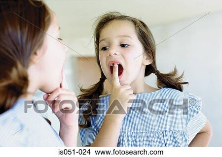 Girl looking at her missing tooth in the mirror View Large Photo Image Picture - Girl looking at her missing tooth in the mirror. Fotosearch