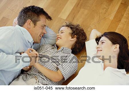 Stock Photography - Mum and dad chilling out with son. Fotosearch