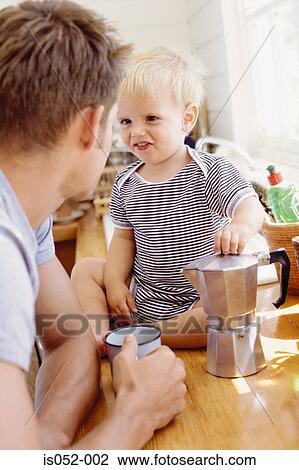 Stock Image - Father and child having breakfast . Fotosearch