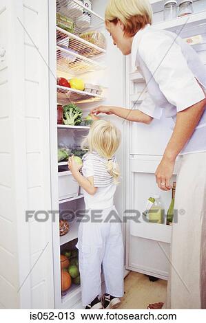 Stock Image - Mother and daughter in the kitchen. Fotosearch