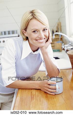 Stock Image - Portrait of woman in the kitchen. Fotosearch