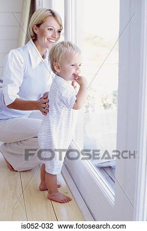 Toddler and mum looking out a window View Large Photo Image Stock Image - Toddler and mum looking out a window. Fotosearch
