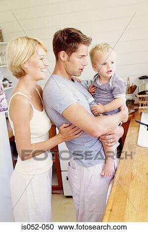 Young parents with child in the kitchen View Large Photo Image Stock Image - Young parents with child in the kitchen. Fotosearch