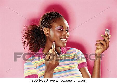 Stock Image - Woman putting make-up on. Fotosearch