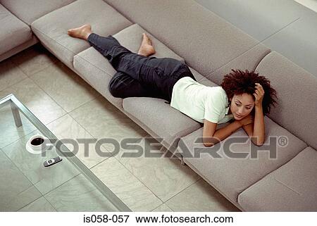 Stock Photo - Woman lying on sofa. Fotosearch