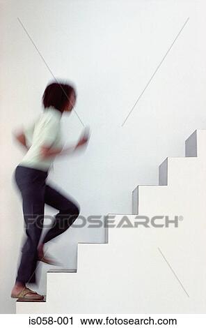 Stock Image - Woman running upstairs. Fotosearch