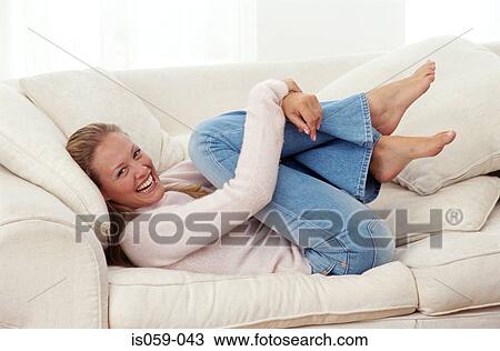 Girl curling up on sofa View Large Photo Image Stock Image - Girl curling up on sofa. Fotosearch