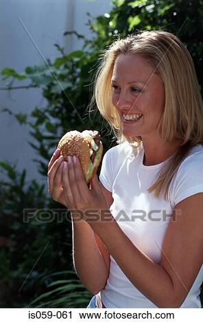 Stock Image - Girl eating hamburger. Fotosearch