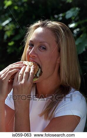 Girl eating hamburger View Large Photo Image Stock Image - Girl eating hamburger. Fotosearch