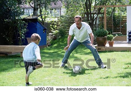 Father and son playing football View Large Photo Image Stock Photo - Father and son playing football. Fotosearch