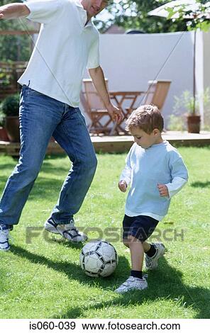Father and son playing football View Large Photo Image Stock Photo - Father and son playing football. Fotosearch