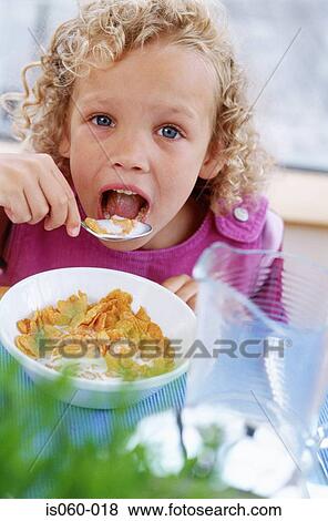 Stock Photo - Girl eating breakfast. Fotosearch