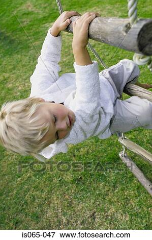 Stock Photo - Boy climbing rope ladder. Fotosearch