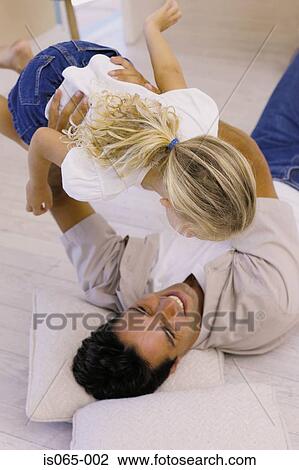 Stock Image - Father holding daughter. Fotosearch