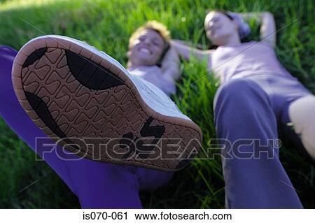 Couple lying in grass View Large Photo Image Stock Image - Couple lying in grass. Fotosearch