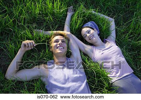 Couple lying in grass View Large Photo Image Stock Image - Couple lying in grass. Fotosearch