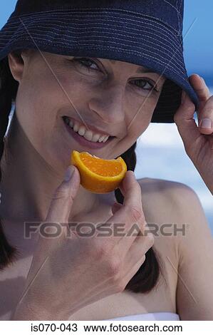 Stock Image - Woman eating orange. Fotosearch