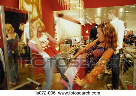 Stock Photograph - Girls in clothes shop. Fotosearch
