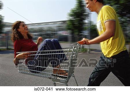 Stock Image - Teenagers with shopping trolley. Fotosearch