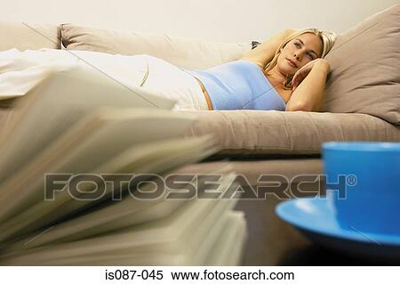 Stock Photography - Girl lying on sofa. Fotosearch