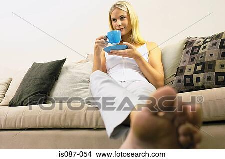 Girl sitting on sofa View Large Photo Image Picture - Girl sitting on sofa. Fotosearch