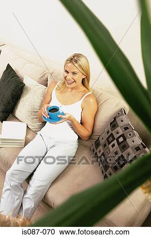 Stock Image - Girl sitting on sofa. Fotosearch