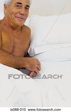 Stock Image - Man on bed. Fotosearch