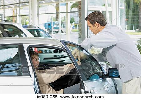 Stock Photography - Man and woman choosing a car. Fotosearch