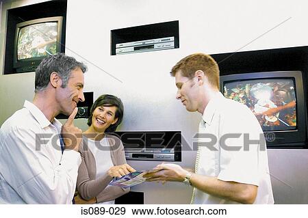 Man and woman looking at televisions View Large Photo Image Stock Photo - Man and woman looking at televisions. Fotosearch