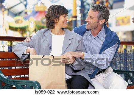 Man and woman sitting on street bench View Large Photo Image Stock Image - Man and woman sitting on street bench. Fotosearch
