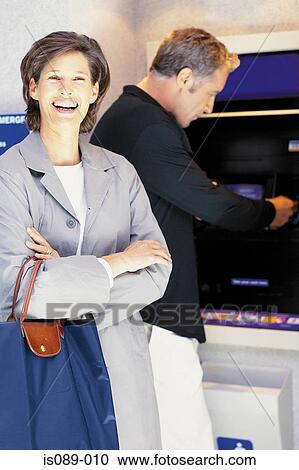 Stock Image - Man and woman withdrawing cash. Fotosearch