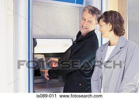 Man and woman withdrawing cash View Large Photo Image Stock Image - Man and woman withdrawing cash. Fotosearch