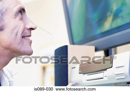 Stock Image - Man looking at television. Fotosearch