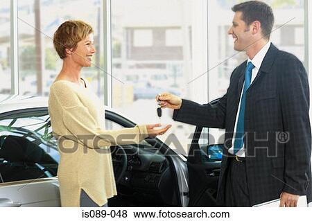 Woman taking car keys from dealer View Large Photo Image Stock Photo - Woman taking car keys from dealer. Fotosearch