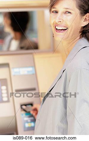 Stock Photograph - Woman withdrawing cash. Fotosearch