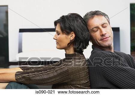 Stock Image - Man and woman leaning against each other. Fotosearch