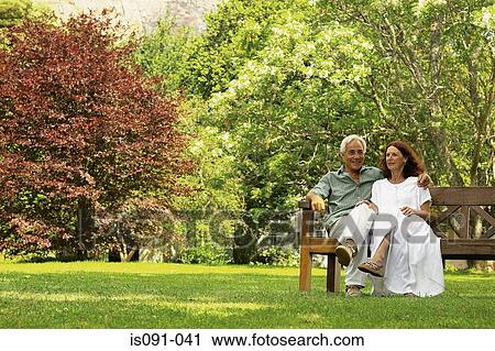 Stock Image - Couple on park bench. Fotosearch