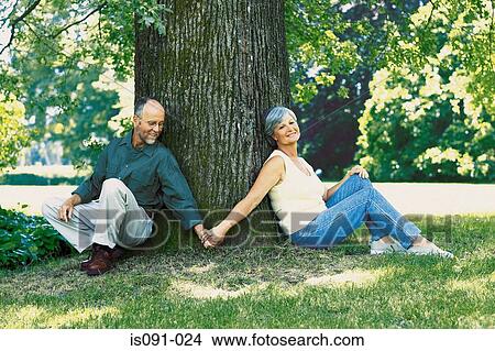 Couple sitting under tree View Large Photo Image Picture - Couple sitting under tree. Fotosearch